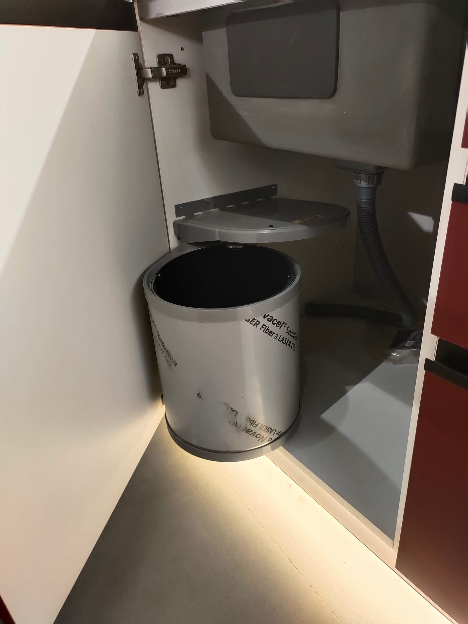 A round bin fixed to a base unit door so it swings clear of the carcass when opened