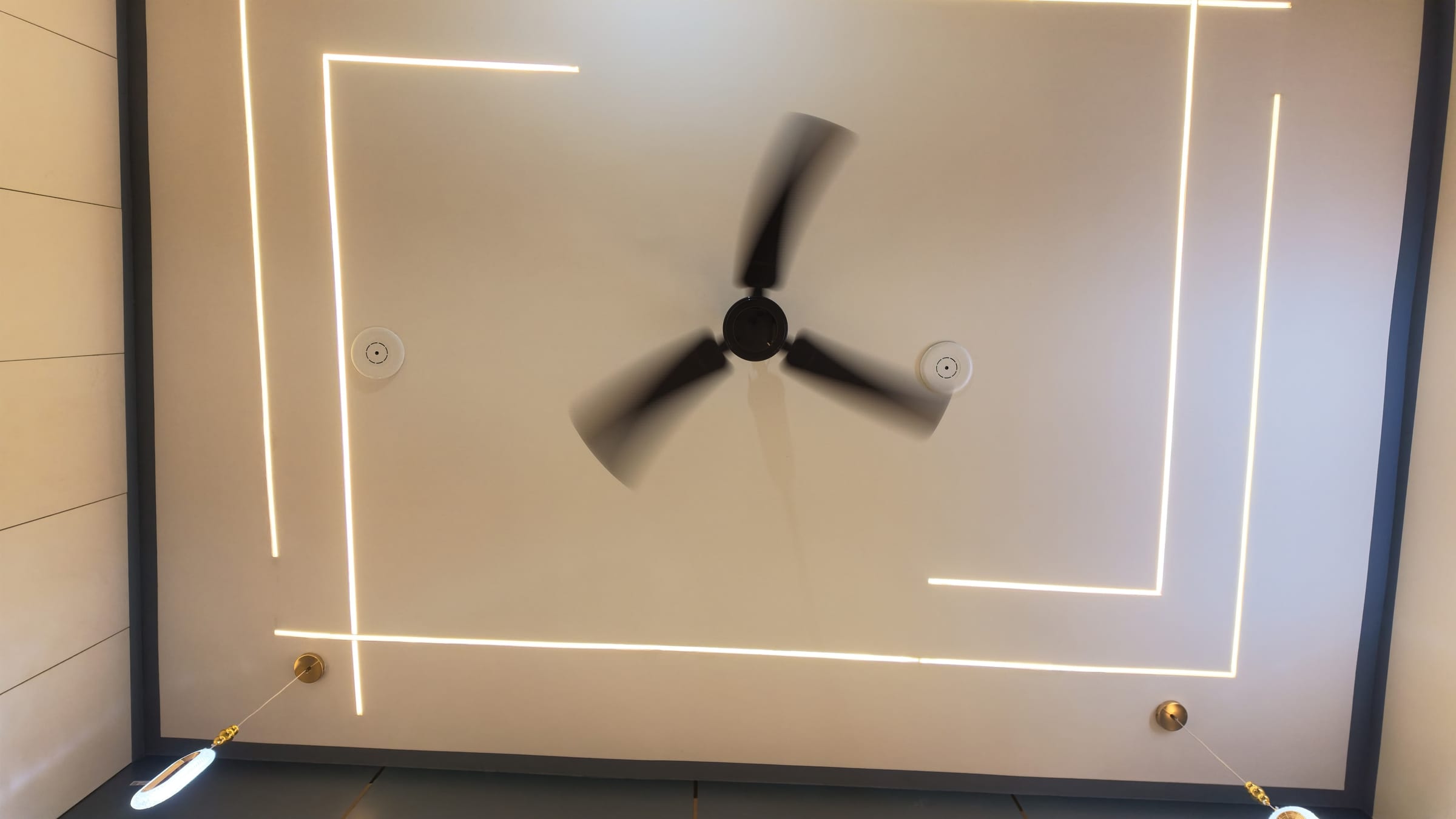 The bedroom ceiling as built, with linear profile lighting set into a recessed panel and two pendant drops