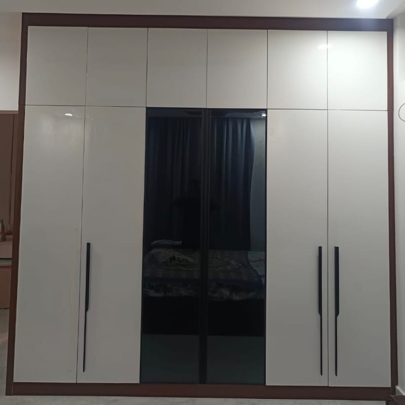 The hinged wardrobe as built, the same six doors and dark wood surround with the centre section glazed in dark glass