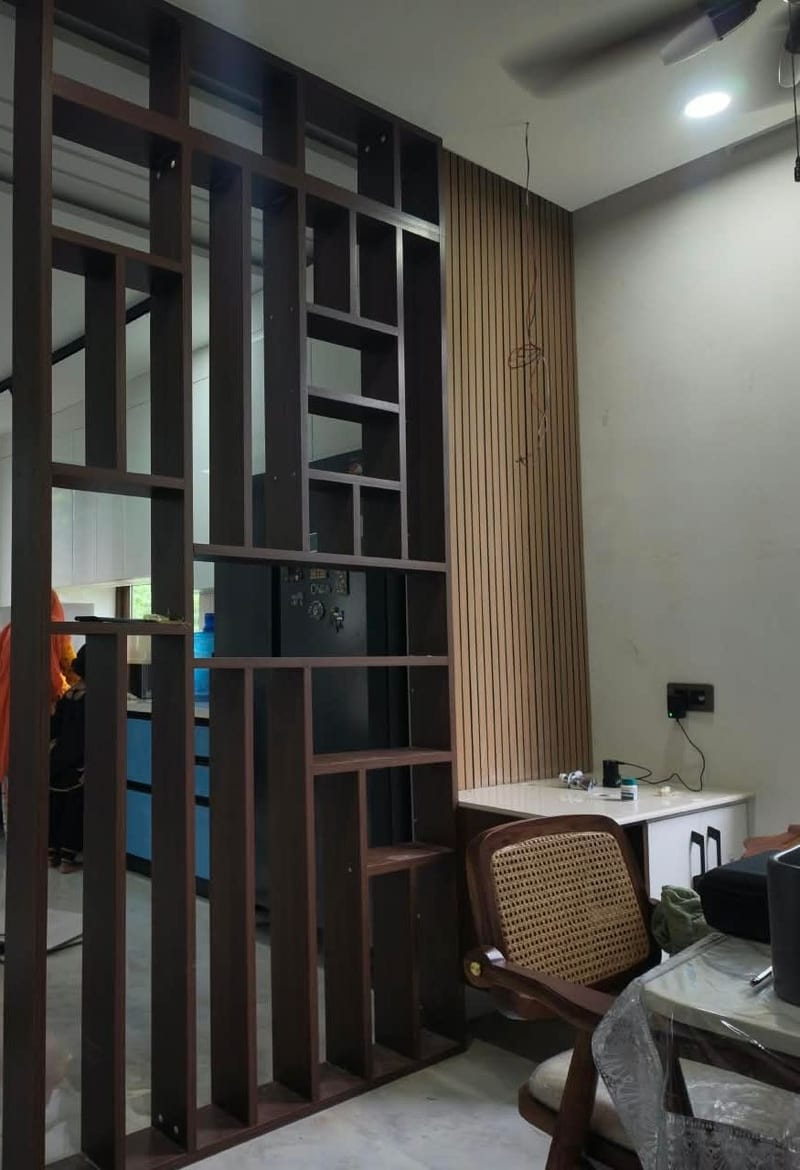 The same open wooden screen as built, its shelf grid dividing the kitchen from the dining area beside a fluted wood wall panel