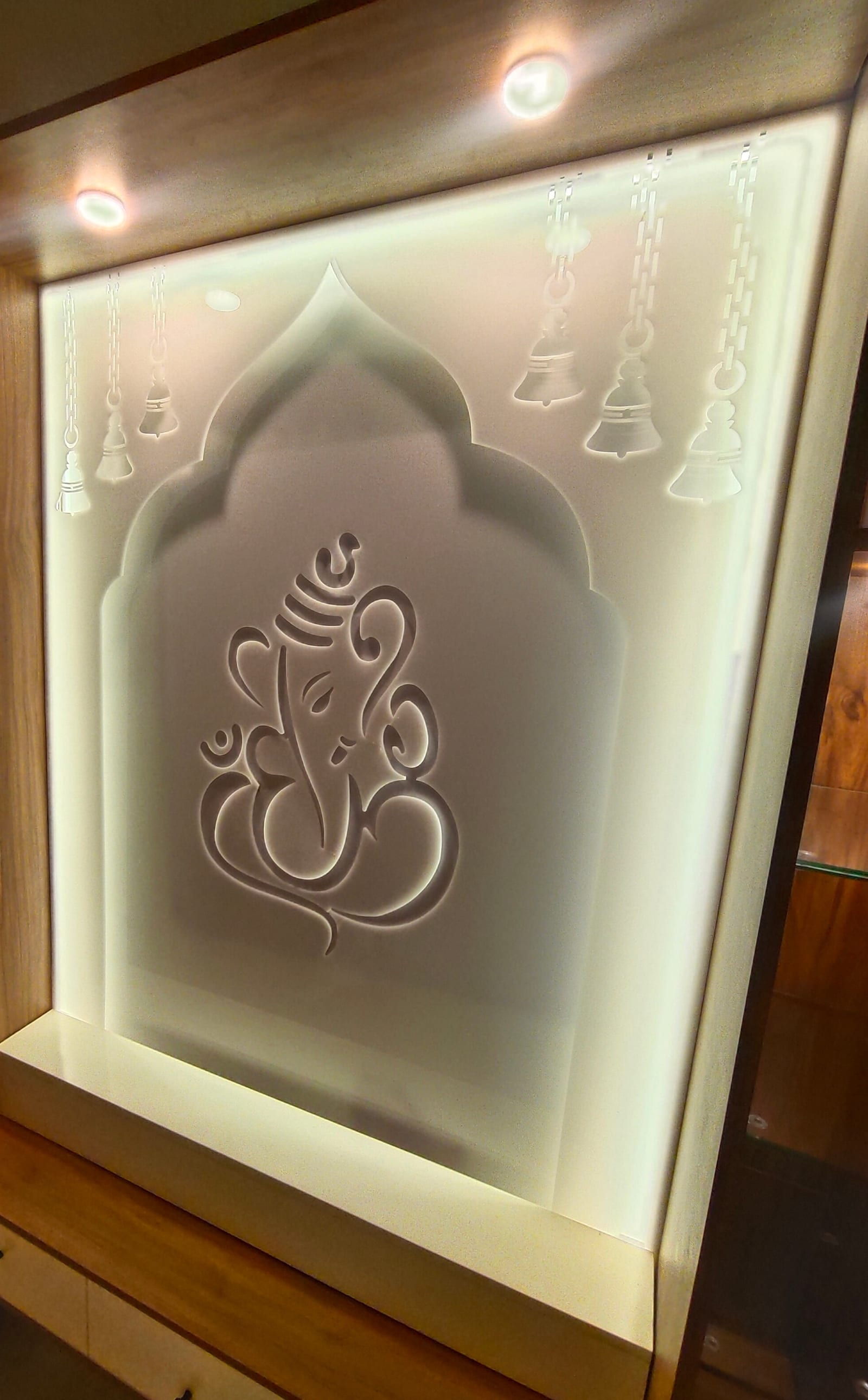 The pooja unit as built, the arch, bells and Ganesh motif etched into glass and lit from behind