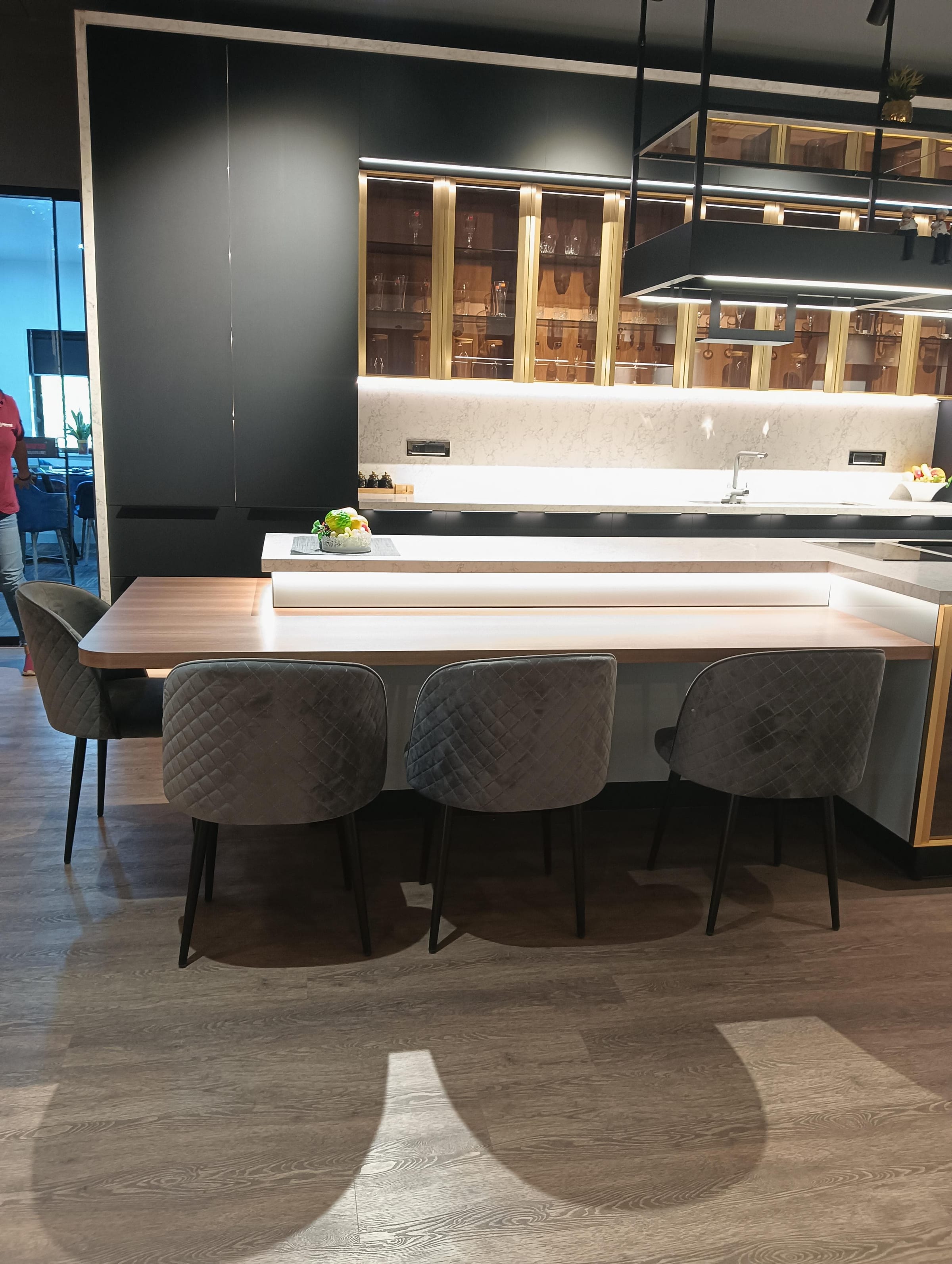 A kitchen with a breakfast bar at the end of the run