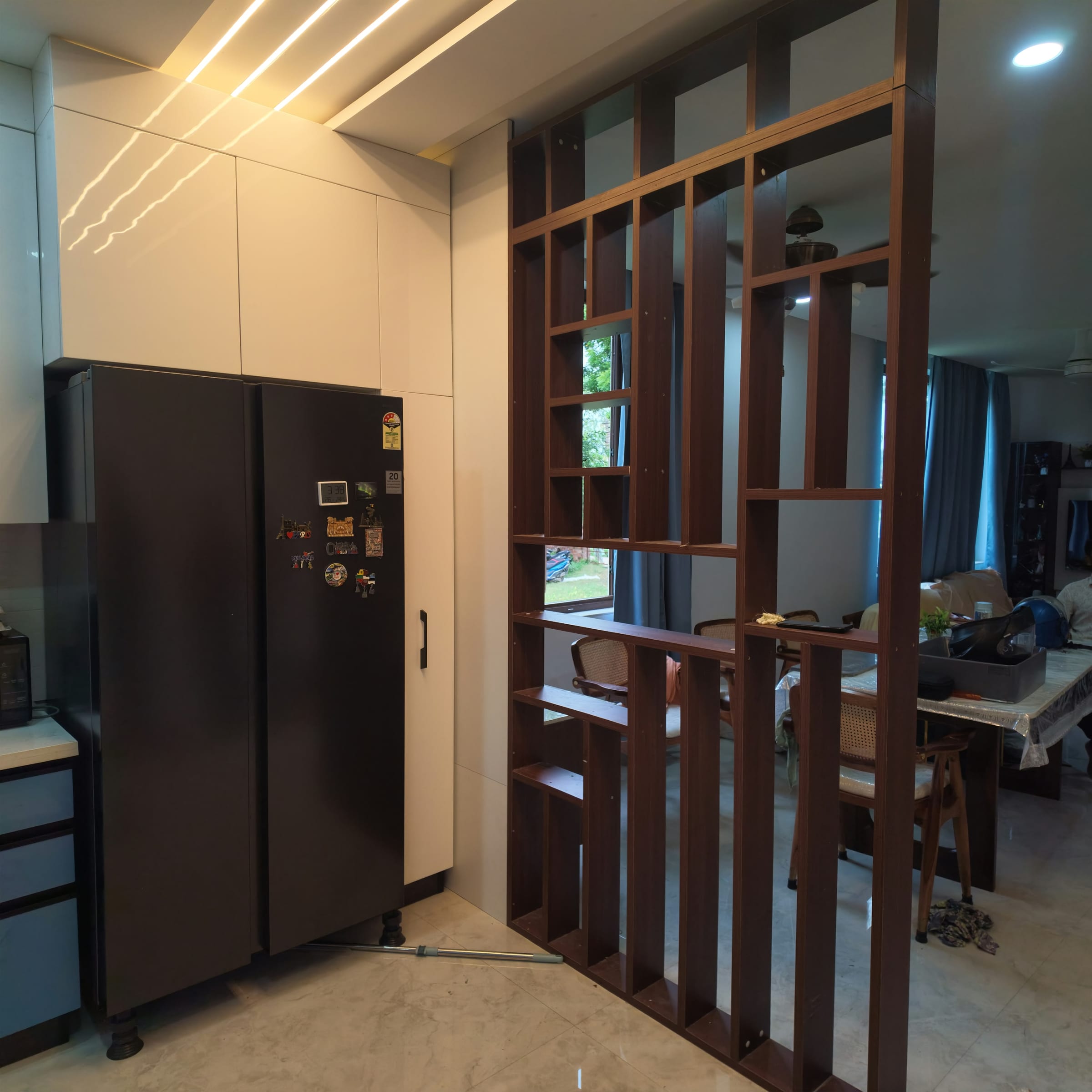 A wooden slatted room divider separating the kitchen from the living area