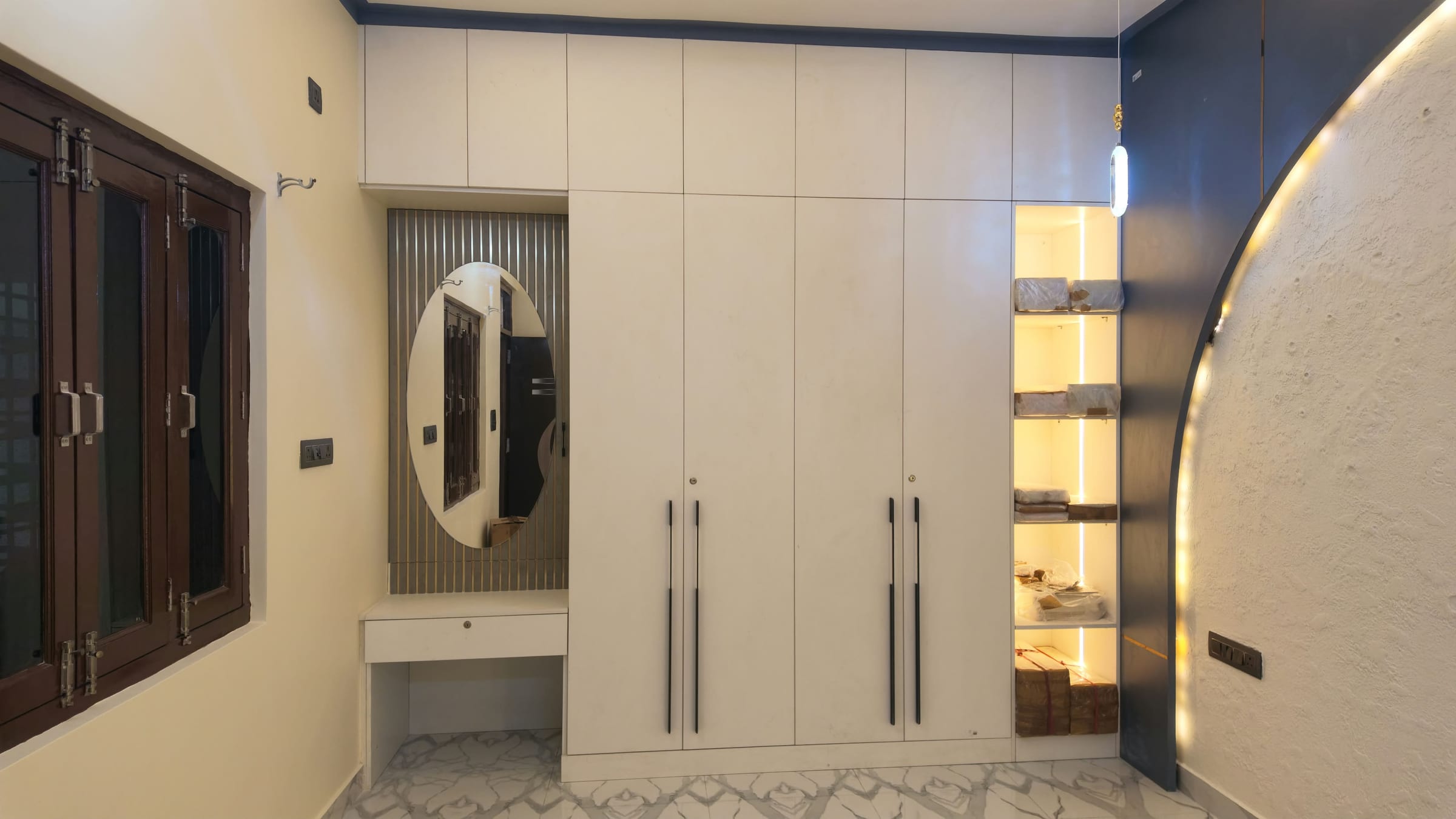 A white hinged wardrobe with a dressing unit and open shelves